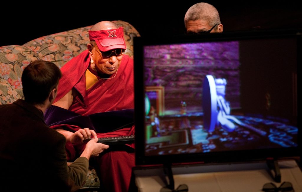 The Dalai Lama wearing 3D glasses to view and interact with a virtual mandala.